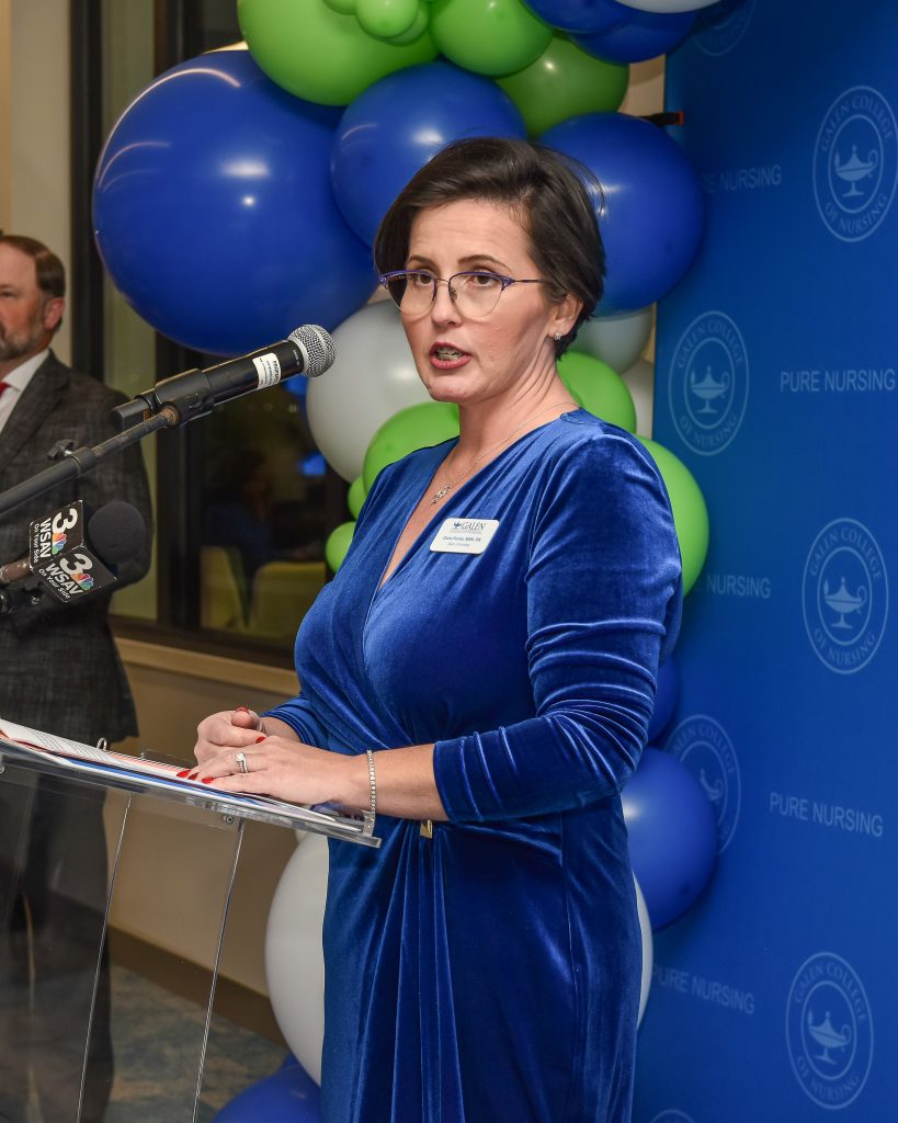 Speaker at a podium during a Galen College of Nursing event with Pure Nursing branding.