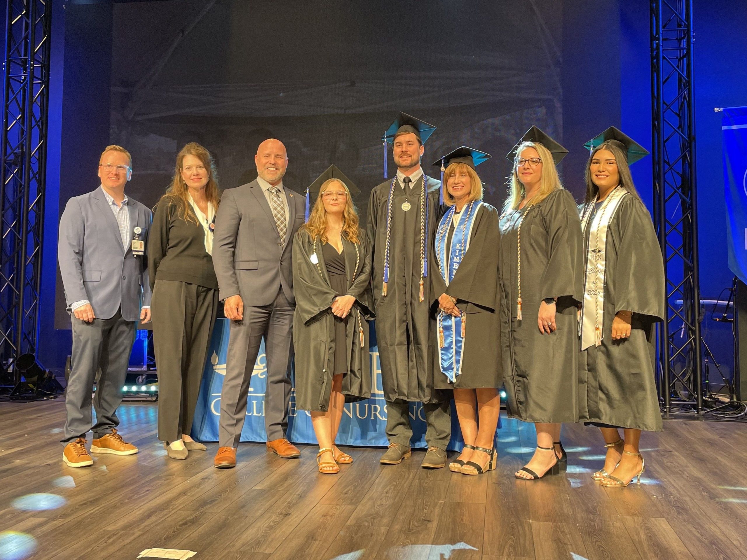 HCA Healthcare Florida West division leaders stand with Galen College of Nursing graduates on stage.