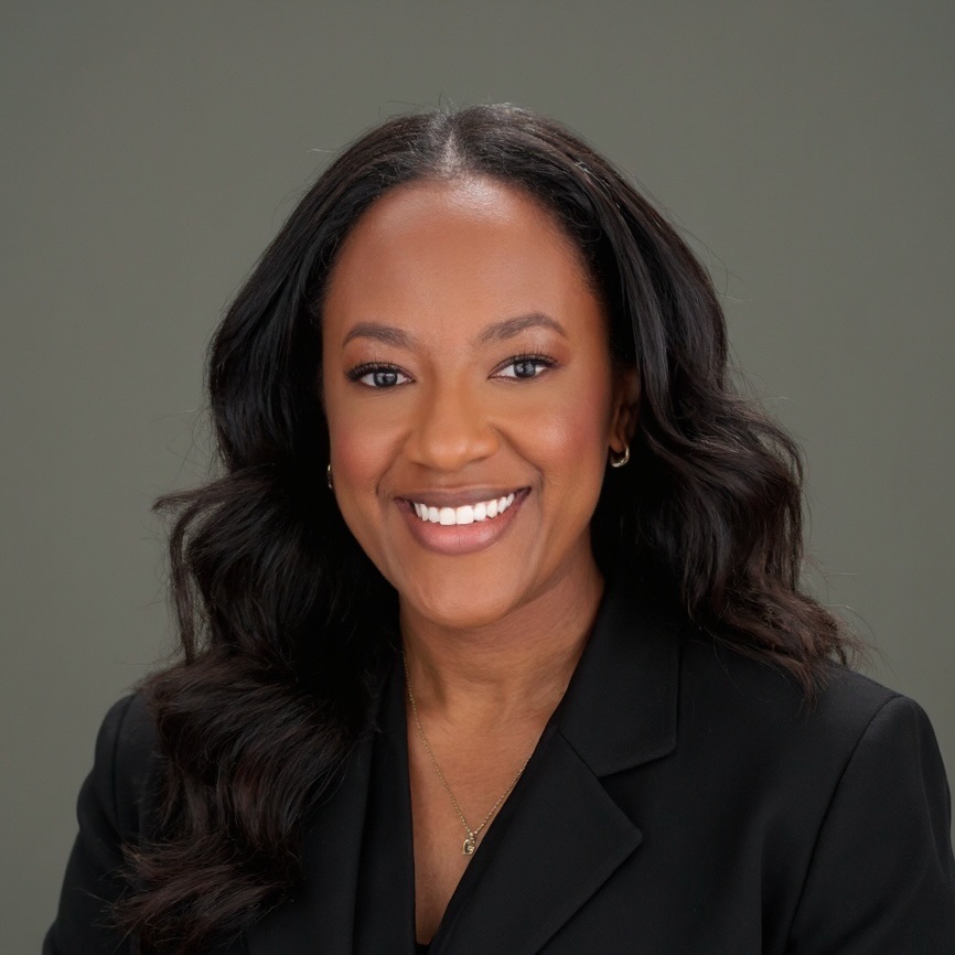 A woman takes a professional headshot with a black top on. 
