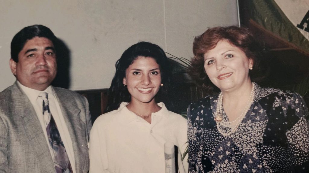 Karla Moore at her high school graduation with father Felix (left) and mother Rosa (right) in Venezuela