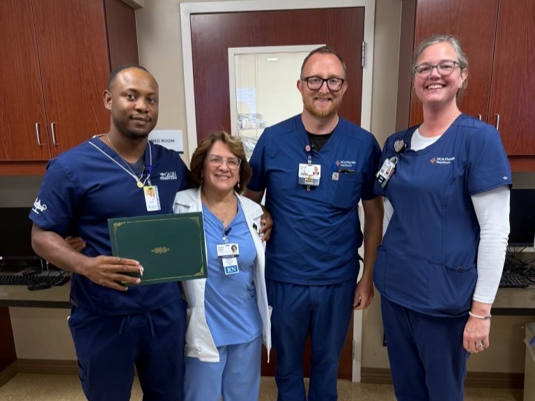 Four people in scrubs pose for a photo