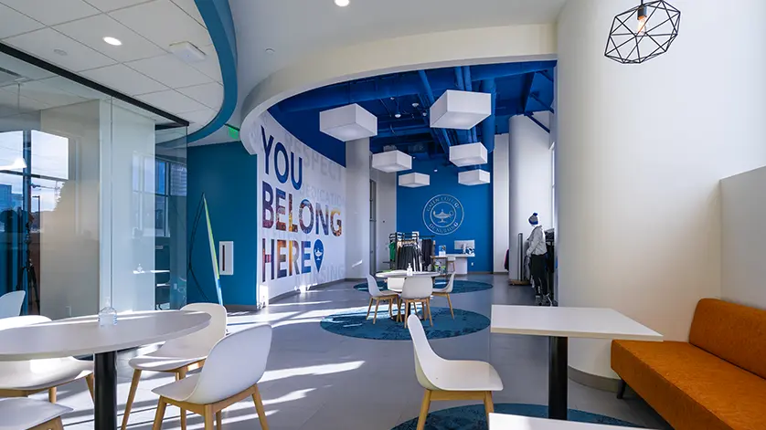 Commons area at Galen Nashville, with small chairs and tables in foreground, Pure Nursing store in background, and a large mural reading You Belong Here.