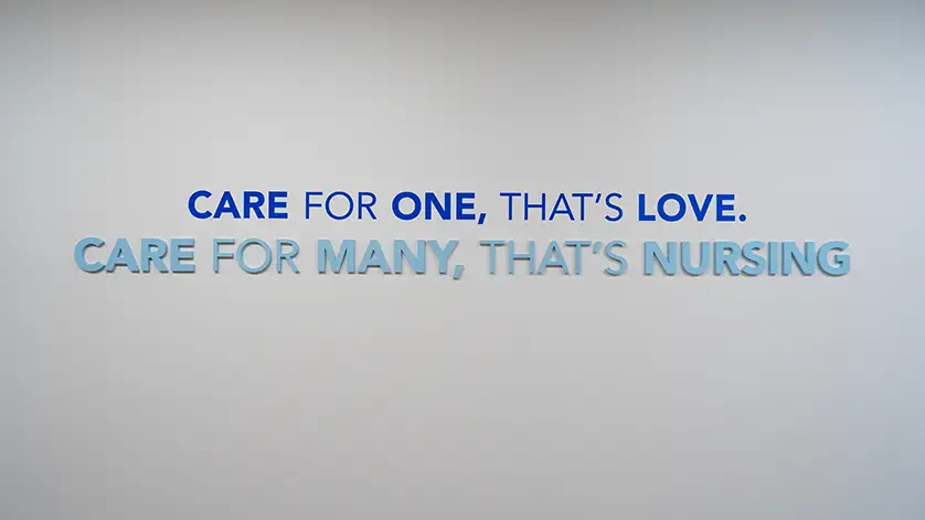 Wall mural that reads Care for One, That's Love. Care for Many, That's Nursing.