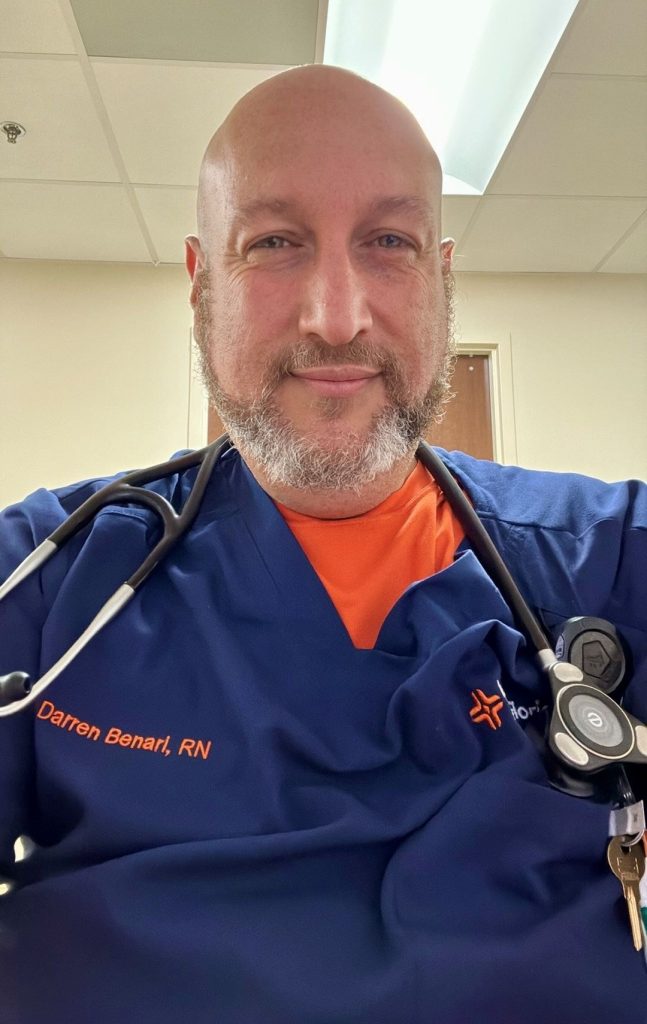 Darren Benari poses in his HCA Healthcare scrubs.