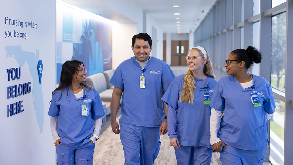 Group of nursing students walking down the hallway smiling and talking.