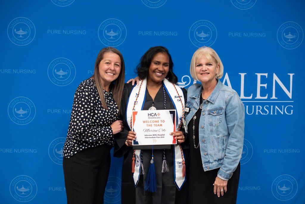 Three people pose for a photo together in front of a blue Galen background.