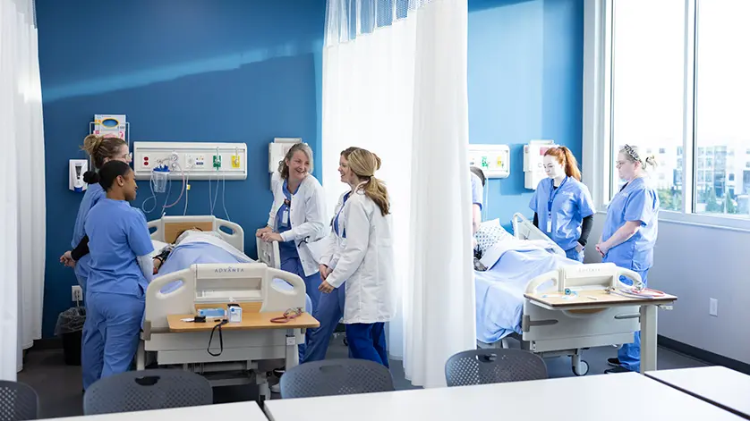 Galen nursing instructors and students gathered around patients in the simulation lab